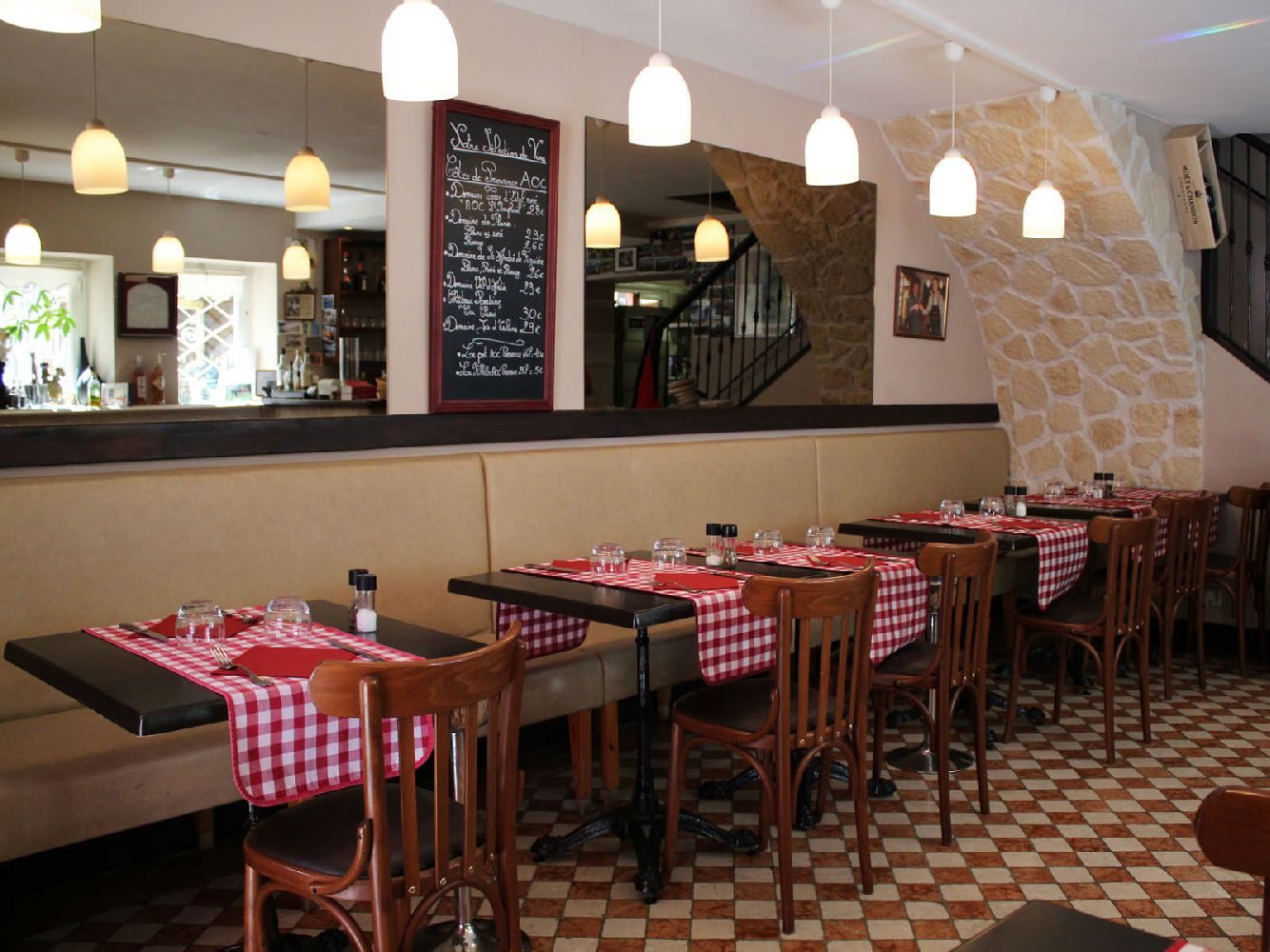 Le comptoir et la banquette, une ardoise encadrée de bordeaux avec la sélection de vins, suspensions blanches